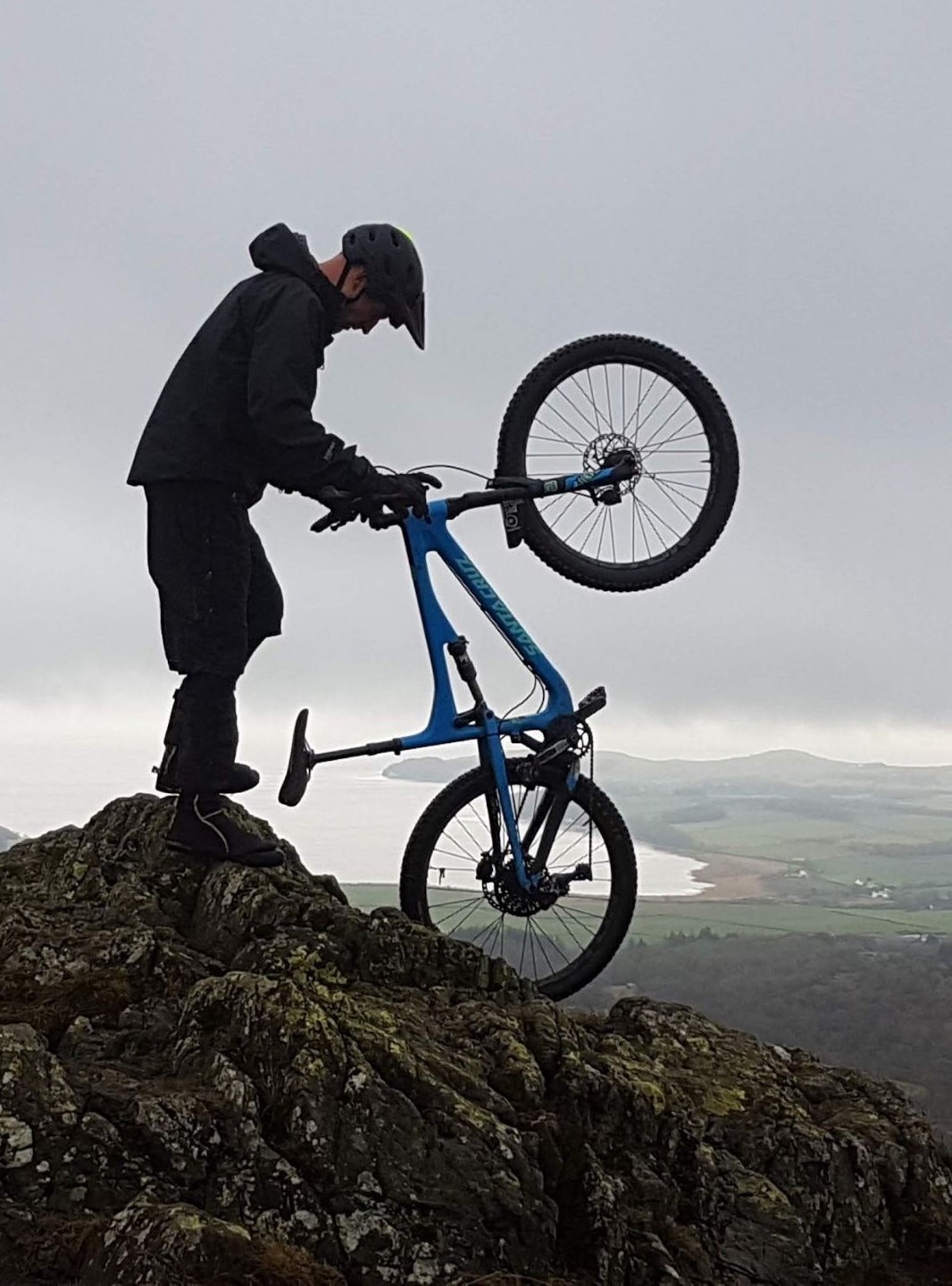 Person walking with bike on top of a mountain